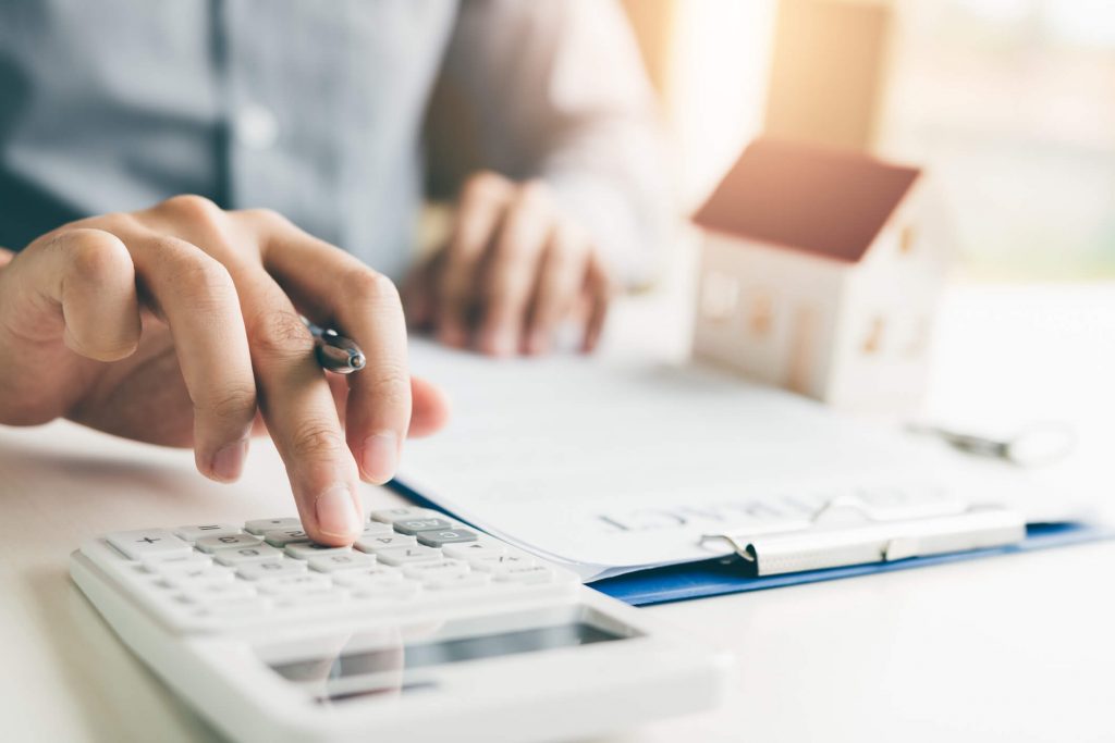 person sitting at desk using calculator