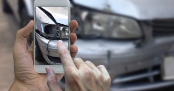 Hand holding smart phone take a photo at The scene of a car crash, car accident for insurance.
