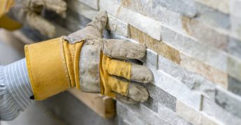 landscaper at work on stone wall