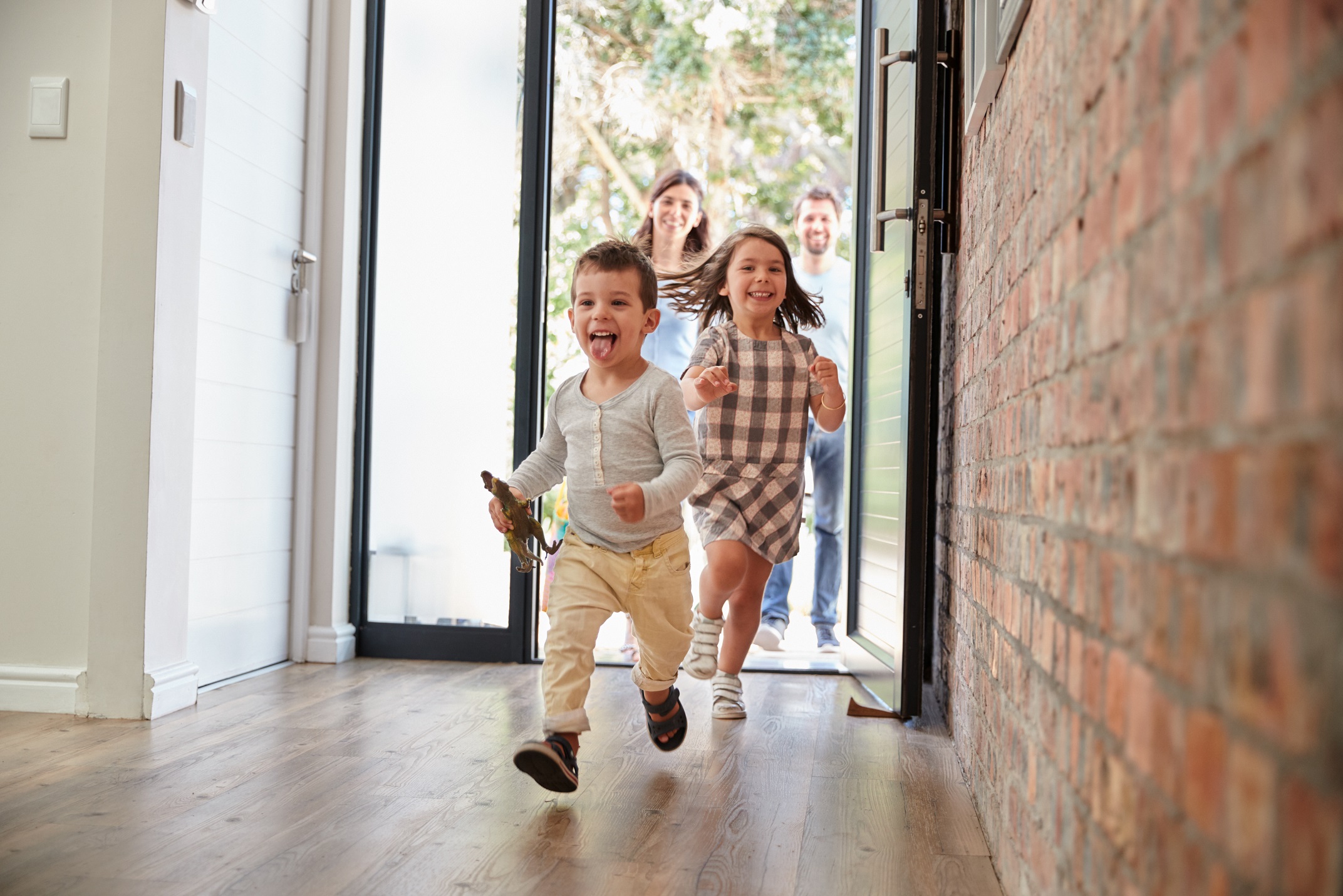 do I need umbrella insurance? two children run into a house through an open front door with two adults looking in through the door in the background