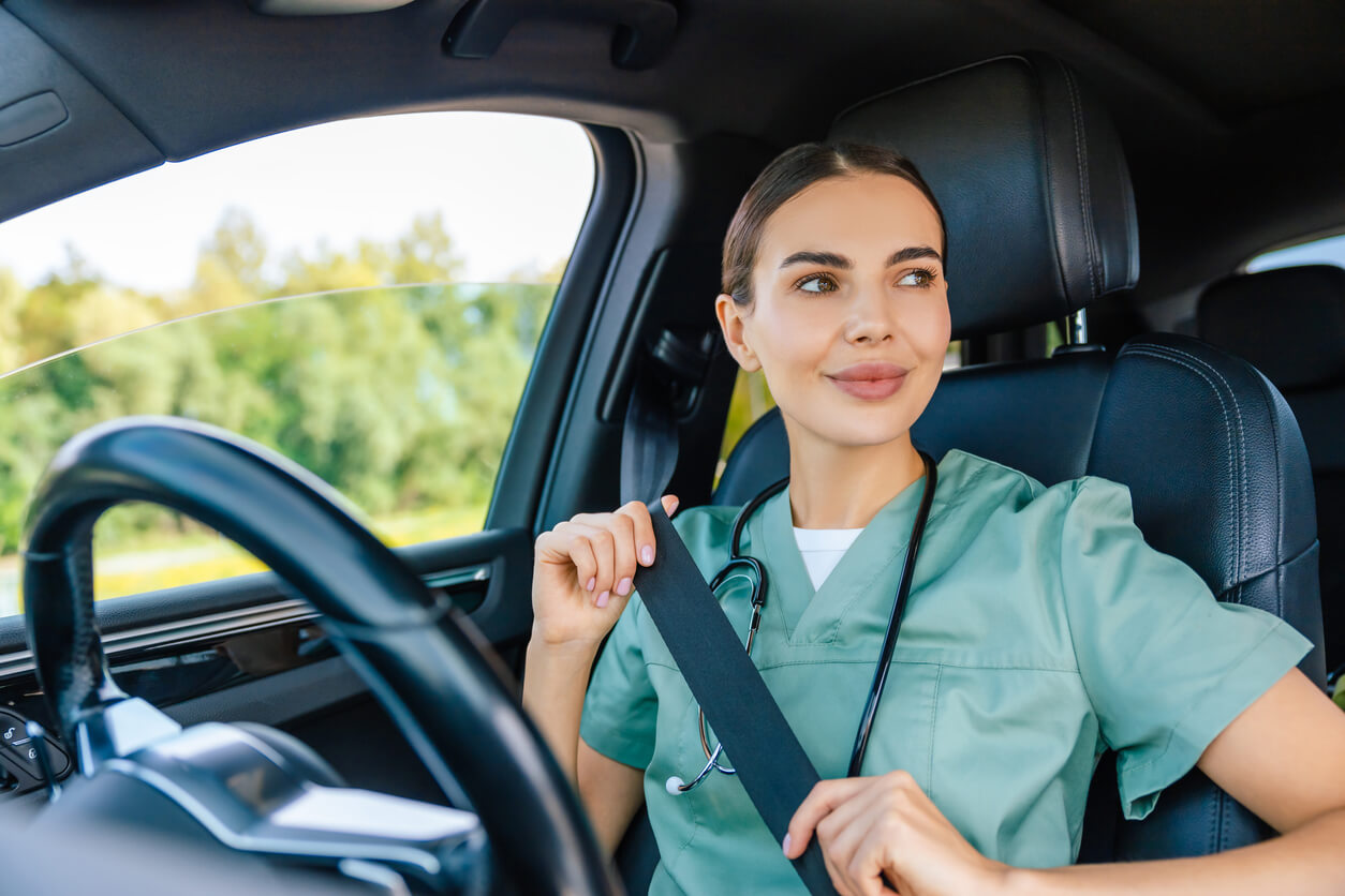 Young woman in scrub suit adjusting a safety belt in the car