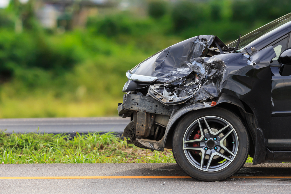 Hood of car severely damaged after a car accident on a highway